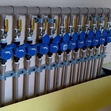 Bateria de hidrômetros individuais azuis instalados lado a lado