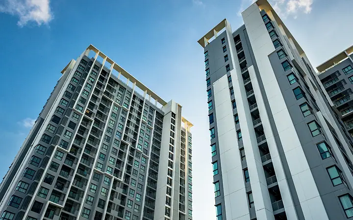 Torres residenciais altas vistas de baixo, contra o céu azul